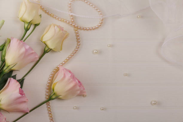 Wedding postcard. Eustoma flowers, delicate veil and beads on a light background