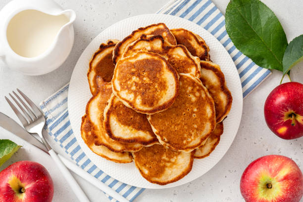 Homemade apple pancakes Homemade apple pancakes in a white plate on a gray concrete background top view. Tasty breakfast dissert stock pictures, royalty-free photos & images