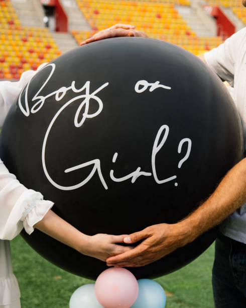 young unrecognizable couple is holding an inflatable balloon with the inscription Girl or boy. Baby shower young unrecognizable couple is holding inflatable balloon with the inscription Girl or boy. Baby shower cute pregnant woman with gift stock pictures, royalty-free photos & images