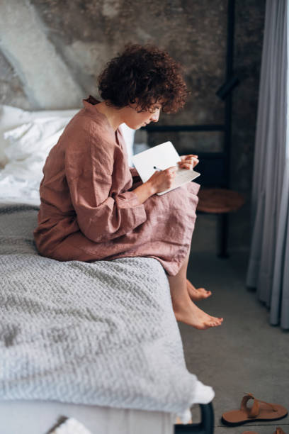 istock Beautiful Woman Writing Notes in Bed at Home 1337645925