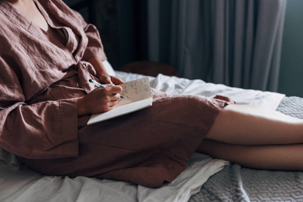 istock An Anonymous Woman Writing Notes in Bed at Home 1337645940