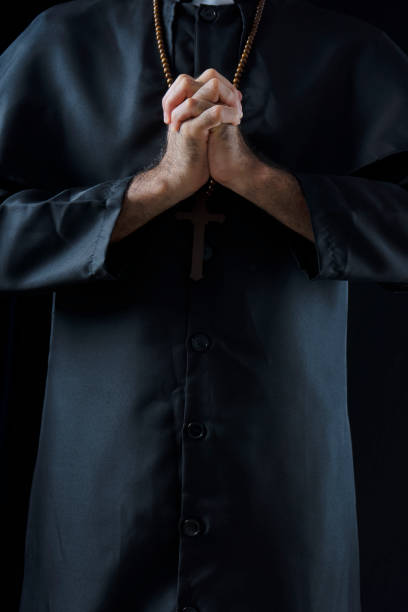 Priest is praying for god. Wooden cross and bible book in hands. Faith and   believe.