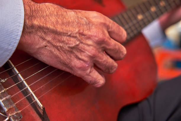 Mature man playing old acoustic guitar