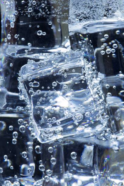 istock Ice and bubbles in cold carbonated drink - black background. 1337650372