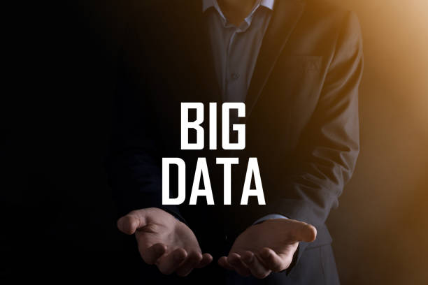 istock Businessman in a suit on a dark background holds the inscription BIG DATA. Storage Network Online Server Concept.Social network or business analytics representation 1337650405