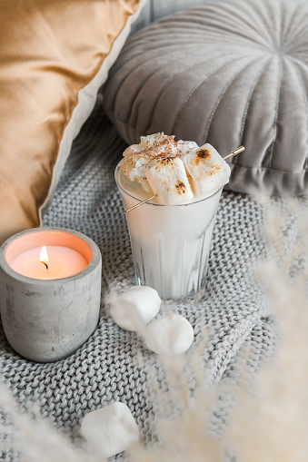 cozy marshmallow milkshake on sofa with candle