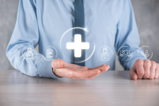 istock Businessman hold virtual plus medical network connection icons. Covid-19 pandemic develop people awareness and spread attention on their healthcare.Doctor,document,medicine,ambulance,patient icon. 1337650613