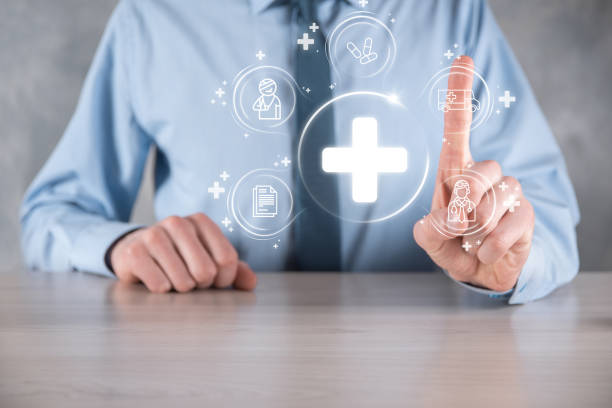 istock Businessman hold virtual plus medical network connection icons. Covid-19 pandemic develop people awareness and spread attention on their healthcare.Doctor,document,medicine,ambulance,patient icon. 1337650617