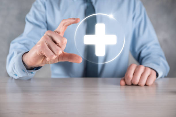 istock Businessman hold virtual plus medical network connection icons. Covid-19 pandemic develop people awareness and spread attention on their healthcare 1337650618