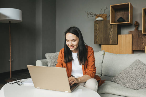 Woman Working at Home on Laptop stock photo