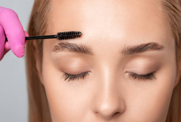 istock Makeup artist combs  and plucks eyebrows after dyeing in a beauty salon.Professional makeup and cosmetology skin care. 1337654303