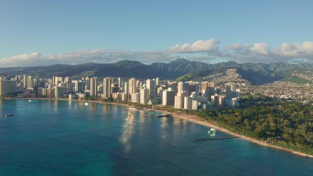 istock Panning aerial drone slowly flying over a colorful Honolulu Skyline while Sunset in Oahu, Hawaii with Waikiki Beach Shooting from a bird's eye view. Magnificent mountains of Hawaiian island of Oahu. 1337654787