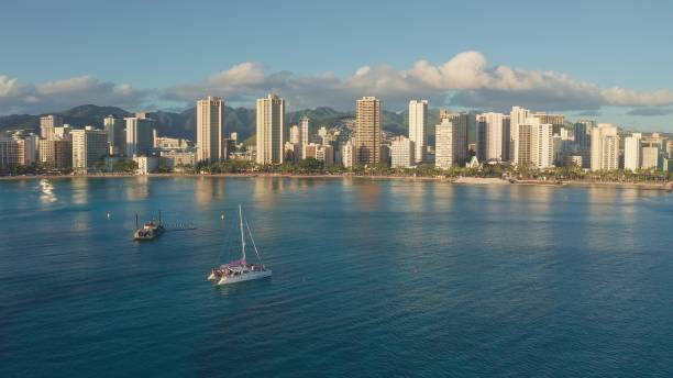 istock Panning aerial drone slowly flying over a colorful Honolulu Skyline while Sunset in Oahu, Hawaii with Waikiki Beach Shooting from a bird's eye view. Magnificent mountains of Hawaiian island of Oahu. 1337654792