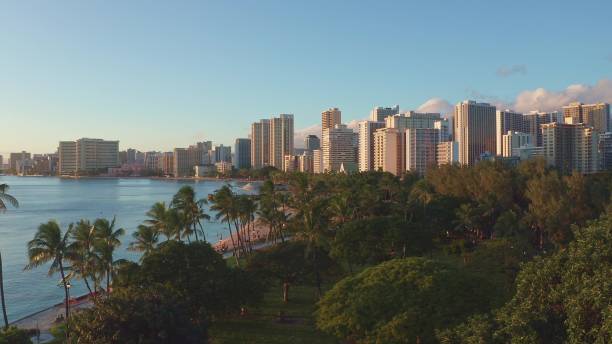 istock Panning aerial drone slowly flying over a colorful Honolulu Skyline while Sunset in Oahu, Hawaii with Waikiki Beach Shooting from a bird's eye view. Magnificent mountains of Hawaiian island of Oahu. 1337654837