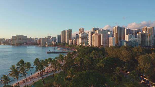 istock Panning aerial drone slowly flying over a colorful Honolulu Skyline while Sunset in Oahu, Hawaii with Waikiki Beach Shooting from a bird's eye view. Magnificent mountains of Hawaiian island of Oahu. 1337654838