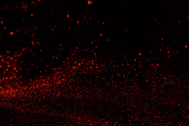 istock Small red glitter on dark black background 1337658293