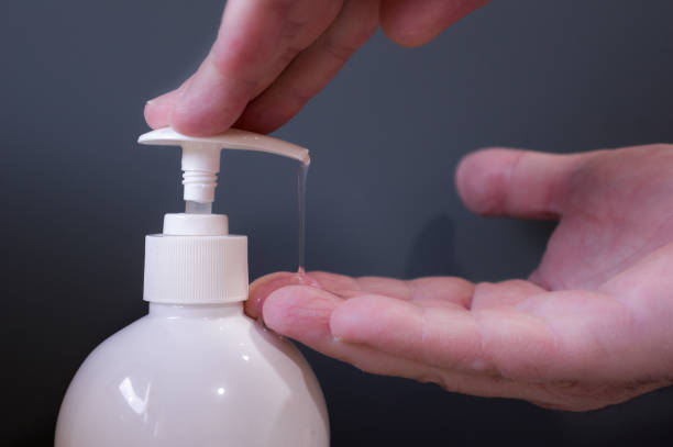 istock Man hands pouring hydroalcoholic gel from white bottle with grey background 1 1337660507