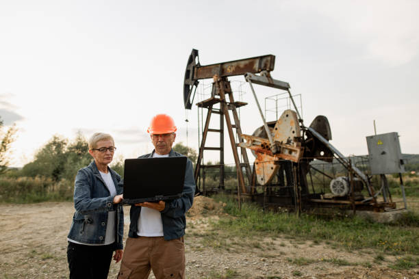 istock Manager with oil worker engineer using laptop at the pumpjack background 1337661851
