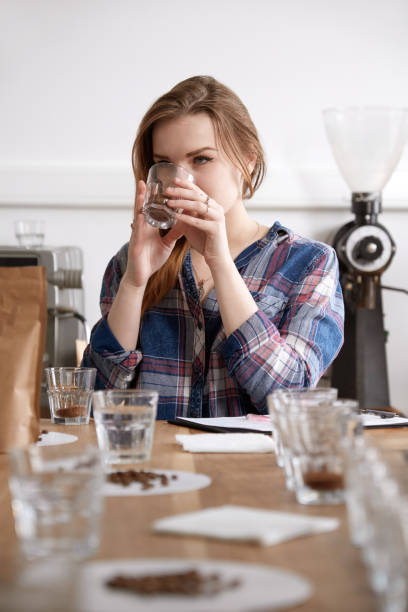 istock Female barista at coffee cupping smelling coffee 1337664614