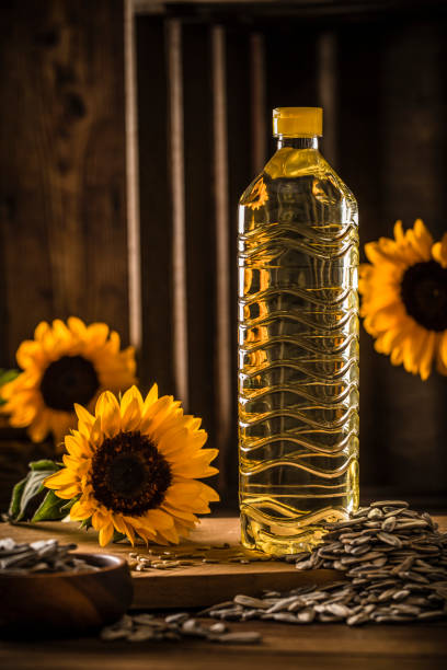 flasche sonnenblumenkernöl auf einem holztisch - sunflower seed oil stock-fotos und bilder