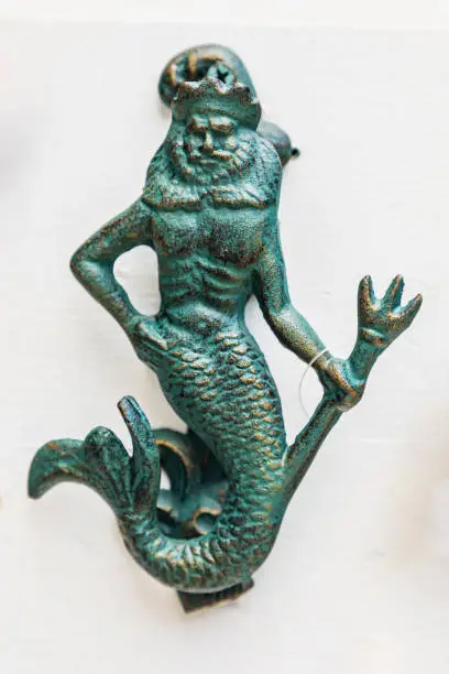 Heceta Head, Oregon, USA. Brass door knocker of a merman holding a trident.