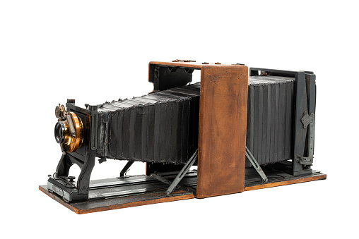 Horizontal angled side shot of an 8×10 glass plate camera manufactured by Folmer and Schwing from approximately 1901  isolated on white.