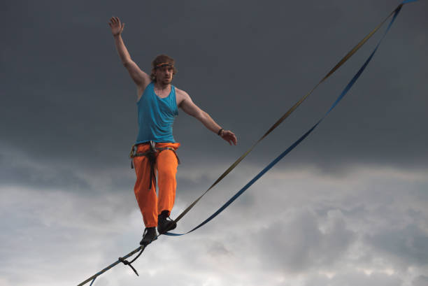 Highliner against a dramatic sky background. Slackline theme Highliner against a dramatic sky background. Slackline theme highlining stock pictures, royalty-free photos & images
