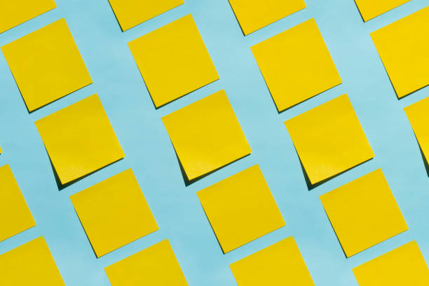 yellow sticky notes on blue background - adhesive note note pad message pad yellow imagens e fotografias de stock