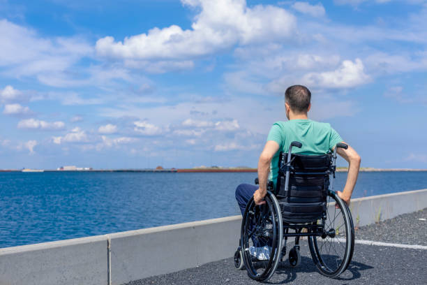 istock Disabled man in a wheelchair admiring the sea 1337679421