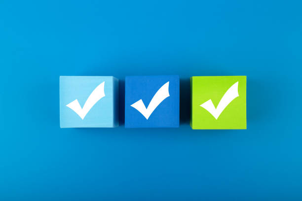 Three checkmarks on toy blocks in the middle of blue background Creative flat lay with three checkmarks close up on blue and green toy cubes in the middle of blue background. Concept of questionary, checklist, to do list, planning or business plans validation photos stock pictures, royalty-free photos & images
