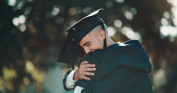 Shot of two students sharing a hug on graduation day