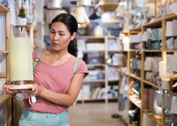 istock Woman choosing table lamp in store 1337695280