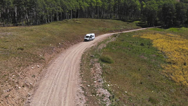 Drone of a custom camper van on a dirt road in the wilds of Southwest Colorado in the summer time