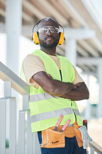 istock Portrait of smiling construction worker wearing hardhat while posing against concrete wall, copy space 1337699818