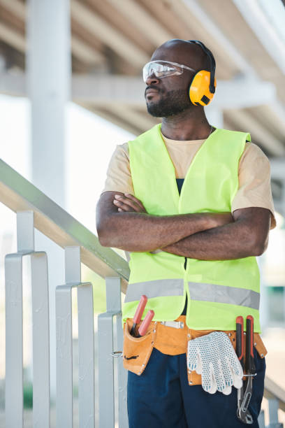 istock Portrait of smiling construction worker wearing hardhat while posing against concrete wall, copy space 1337699865
