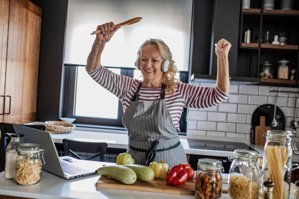 istock Senior woman having fun and singing in the kitchen 1337701029