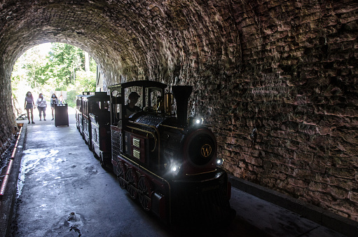 Small tourist train getting in Canada first railway tunnel in Brockville during summer day