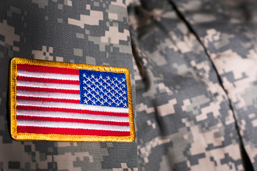 American flag on sleeve of US Military Uniform.  Veteran's Day and Memorial Day tributes.