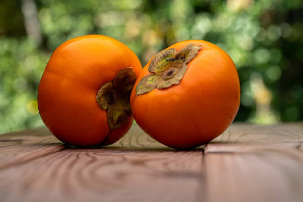Photo of persimmons on a wooden board.