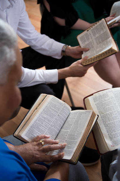 bible study.   multi ethnic group.
multi ethnic group of friends meet for a bible study.  group includes teenager, young adults, mid-adults and senior adult.  close up of bibles. - bible holding reading book imagens e fotografias de stock