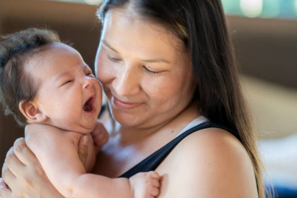 彼女の母親に抱かれている間にあくびをする新生児の女の赤ちゃん - native american baby love mother ストックフォトと画像