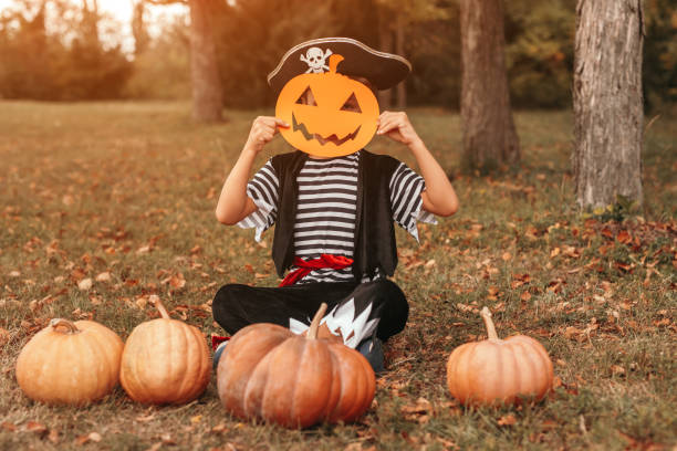 istock Funny kid with pumpkins and paper mask 1337722206