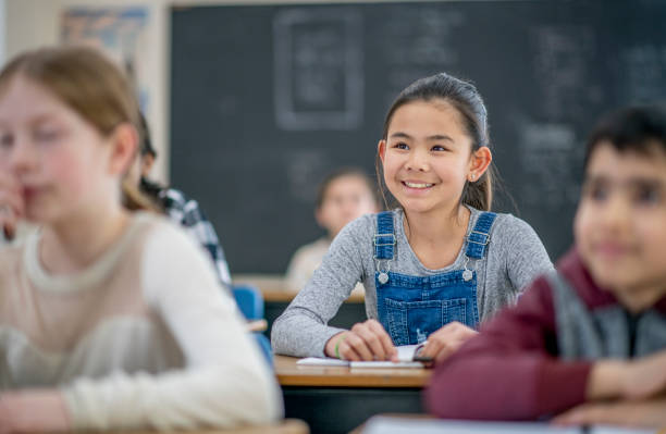 istock Smiling elementary school girl sitting in a classroom 1337723031
