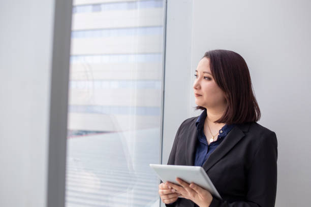 istock japanese woman looking out the office window 1337725616