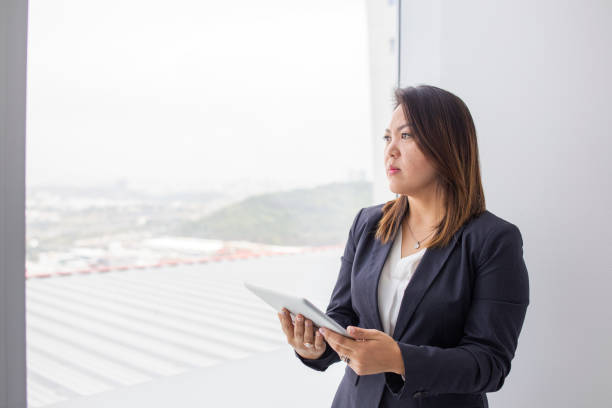istock japanese woman looking out the office window 1337725648