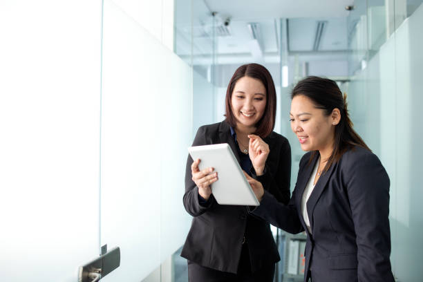 istock Two women chatting in the office hallway 1337726168
