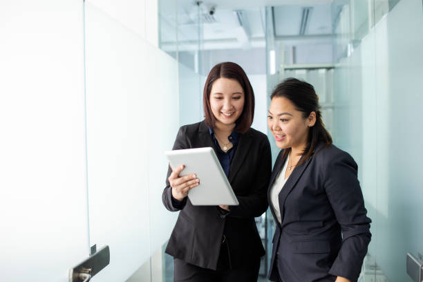 istock Two women chatting in the office hallway 1337726169