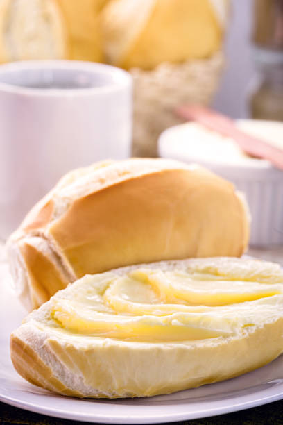 fatia de pão salgado cortado com manteiga, chamado pão francês no brasil, café da manhã brasileiro - butter bread breakfast table - fotografias e filmes do acervo