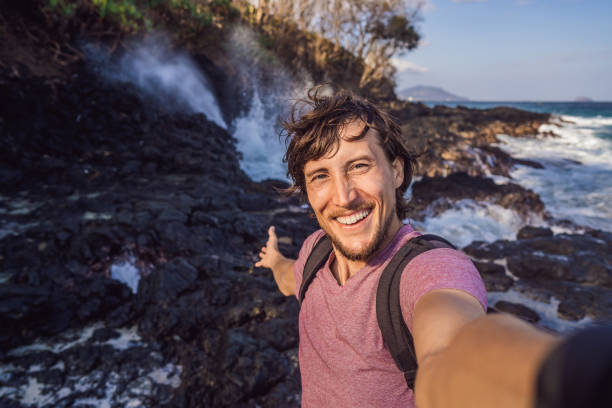 istock Smiling guy in the sea spray on the rocks 1337729805