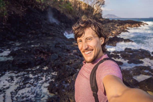istock Smiling guy in the sea spray on the rocks 1337729806